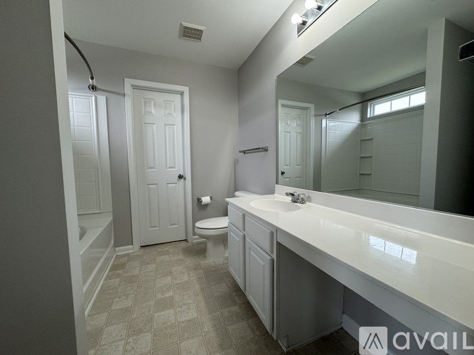A bathroom with a toilet, sink, and mirror.