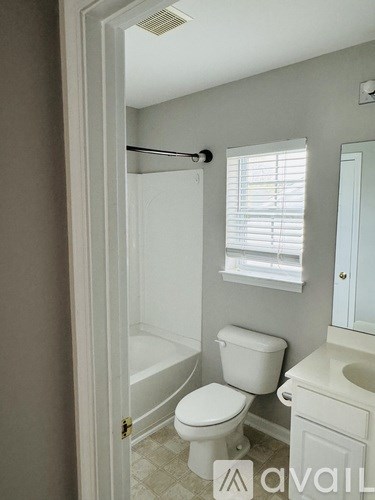 A bathroom with a toilet, sink, and shower.