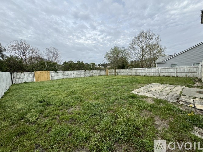 A backyard with a fence and a small shed.