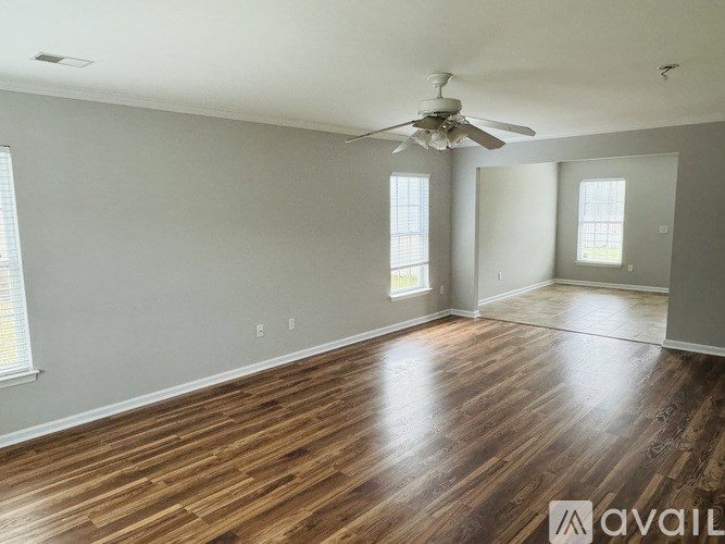 A room with wooden floors and a ceiling fan.