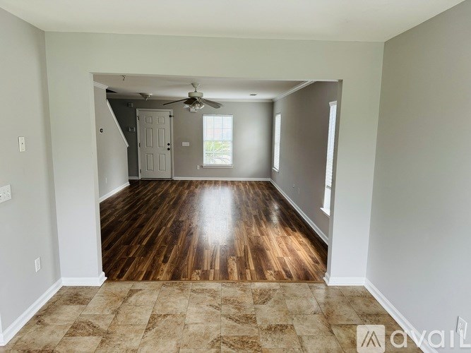 A room with wooden floors and a ceiling fan.