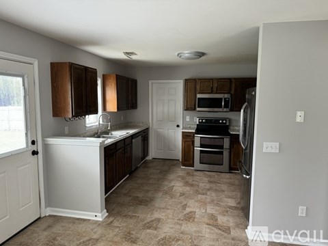 A kitchen with white cabinets and a tiled floor.