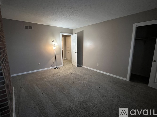 A room with a carpeted floor and a doorway leading to another room.