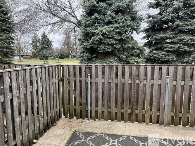 A wooden fence with a mat on the ground in front of it.
