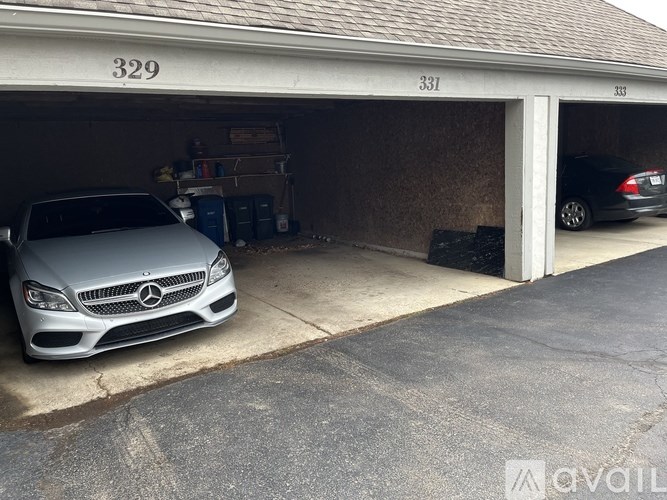 A Mercedes-Benz car is parked in a garage with the numbers 329 and 331 on the wall.