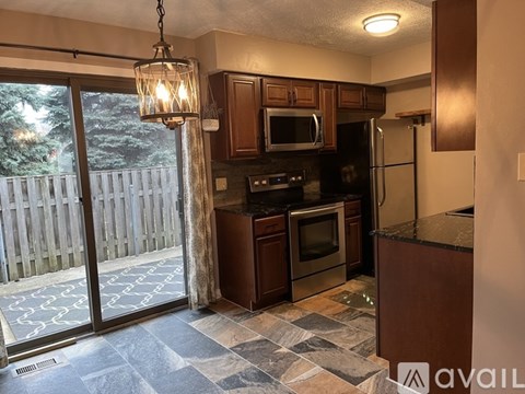 A kitchen with a black granite countertop and stainless steel appliances.