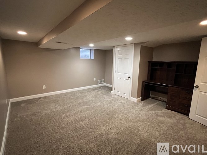 A room with a carpeted floor and a white door.