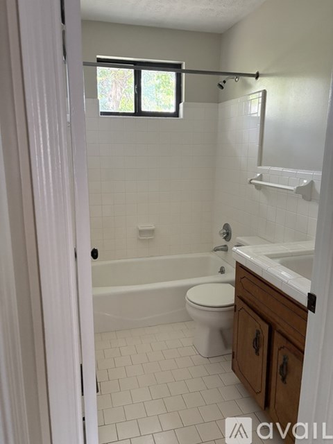 A bathroom with a toilet, sink, and bathtub.