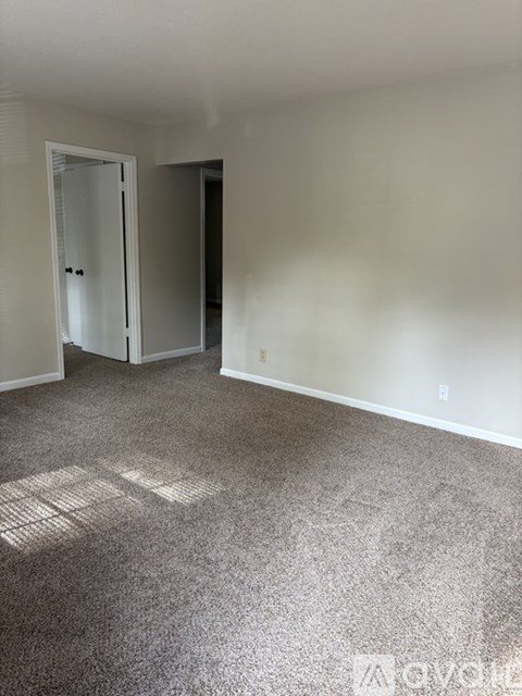 A room with a carpeted floor and a door.