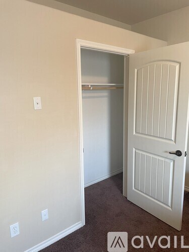 A white door is open to a room with a carpeted floor.