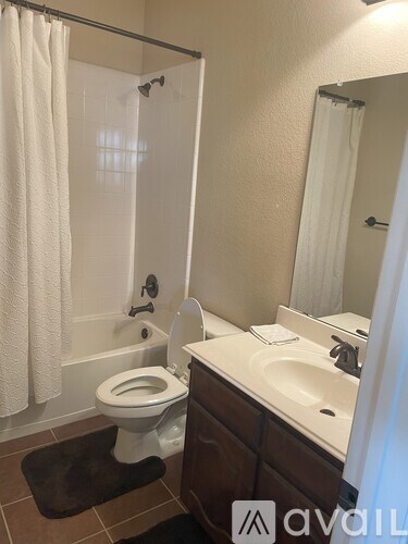 A bathroom with a toilet, sink, and shower.