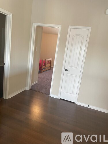 A room with a white door and a white wall.