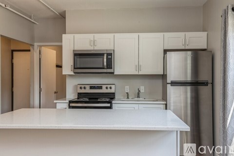 A kitchen with white cabinets and appliances.