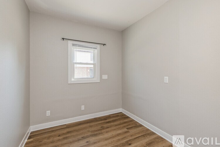 A room with a window and wooden flooring.