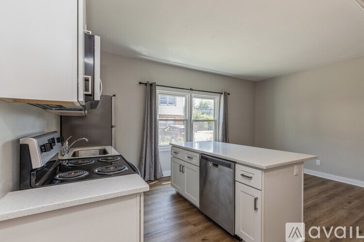 A kitchen with white cabinets and a stove top oven.