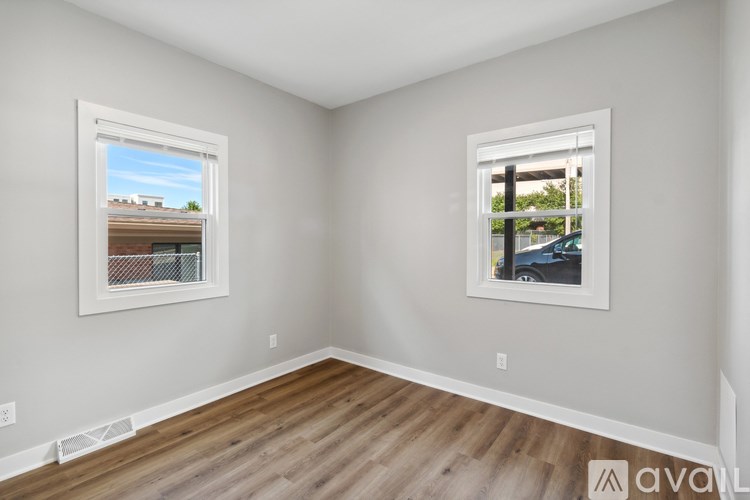 A room with two windows and wooden flooring.
