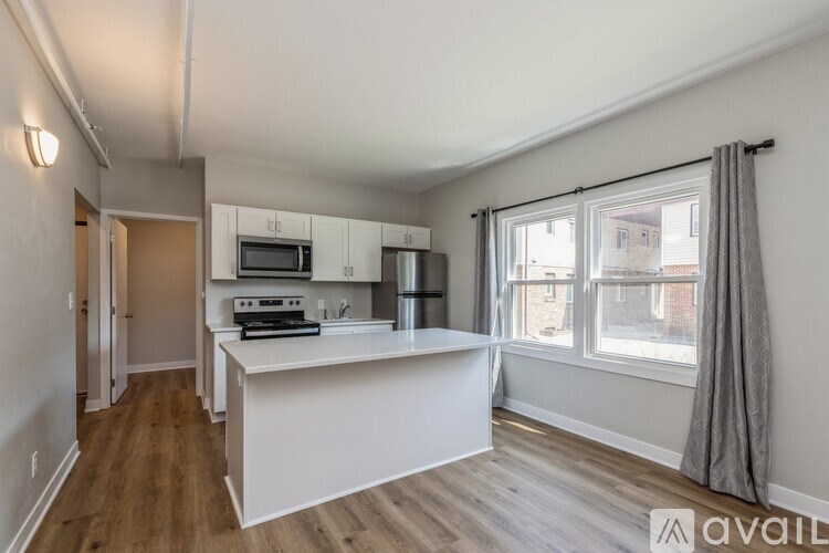 A kitchen with a white countertop and wooden floors.
