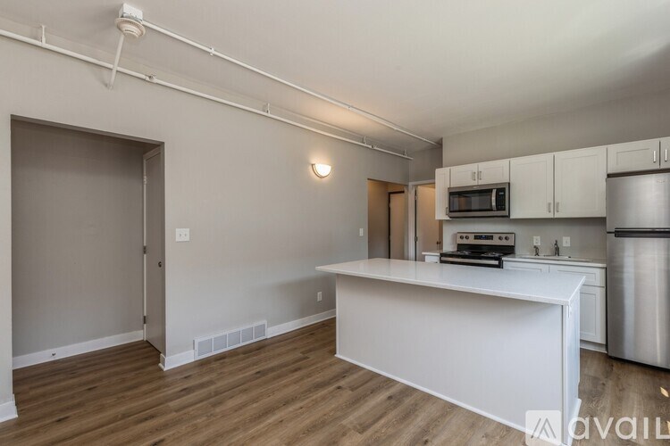 A kitchen with white countertops and stainless steel appliances.