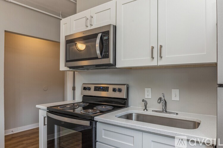 A kitchen with a stove, microwave, and sink.