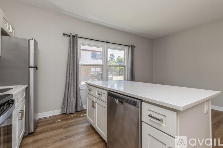 A kitchen with a white countertop and stainless steel appliances.