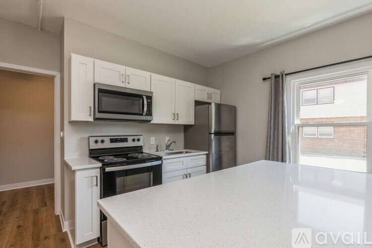 A kitchen with white cabinets and a white countertop.