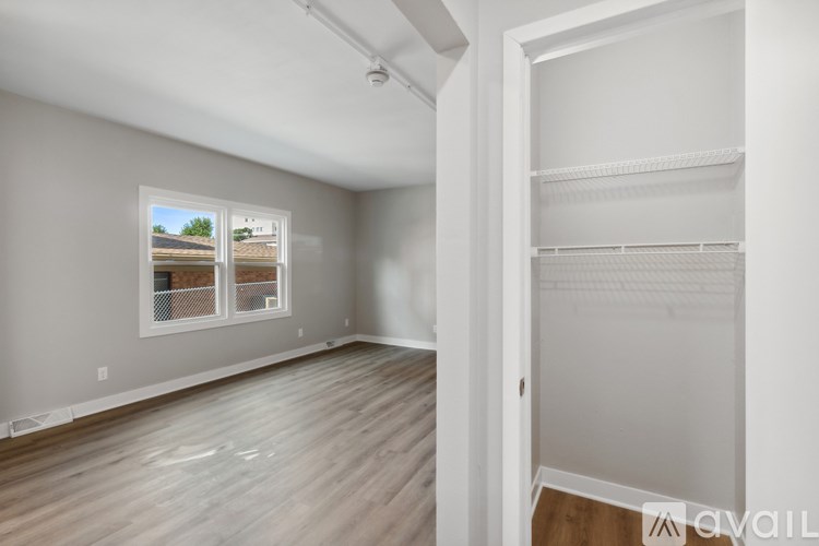 Empty room with a window and a door leading to another room.