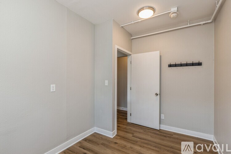 A room with a white door and a shelf on the wall.