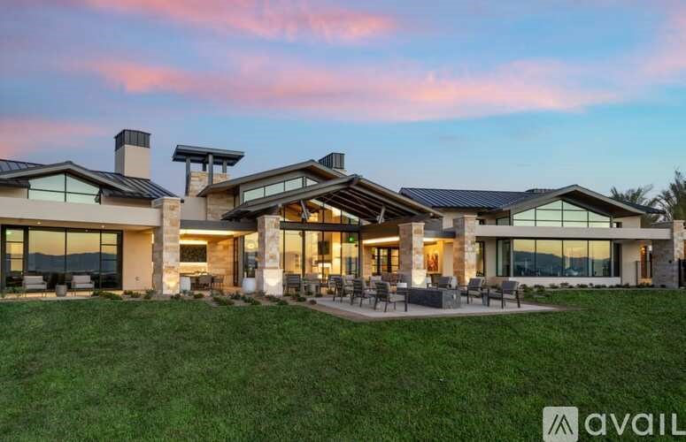 A modern house with a spacious lawn and outdoor furniture.