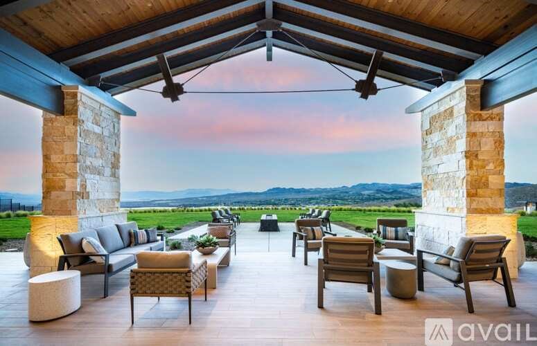 A patio with a view of the countryside at dusk.