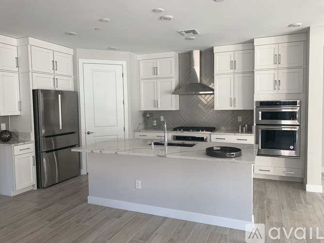A modern kitchen with white cabinets and stainless steel appliances.