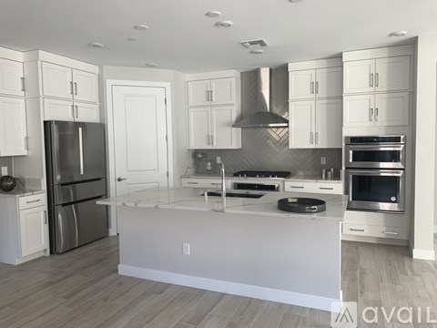 A modern kitchen with white cabinets and stainless steel appliances.