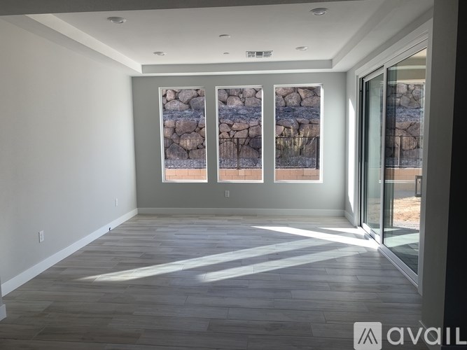 A spacious room with a view of a rocky landscape through the windows.