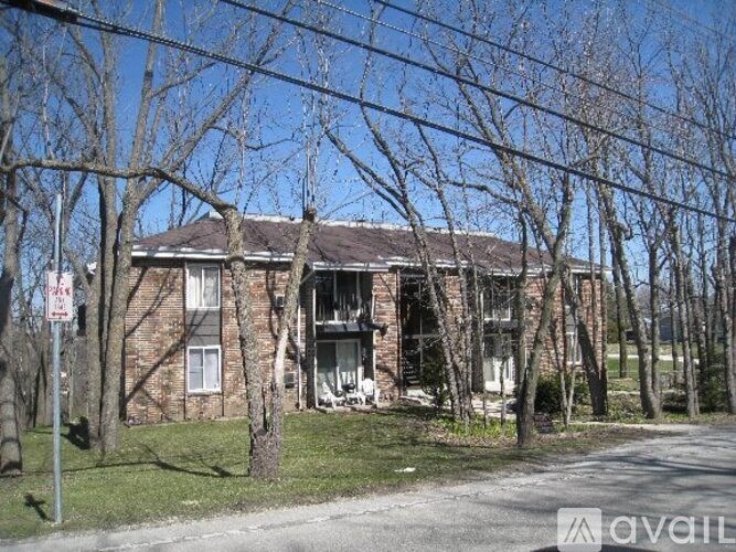 A burnt out building with trees in front.