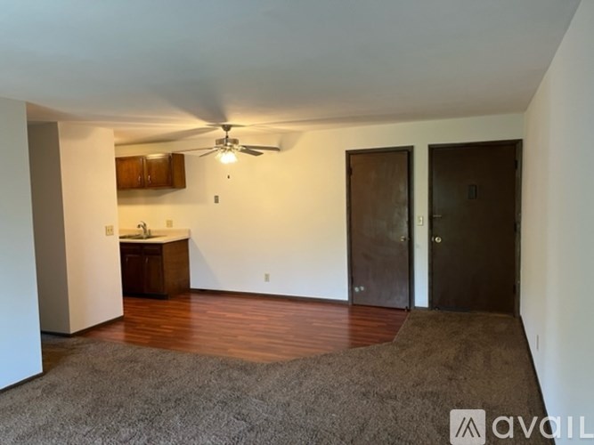 A room with a ceiling fan and two doors.