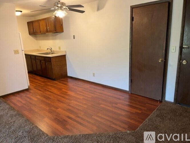 A kitchen with wooden floors and a ceiling fan.