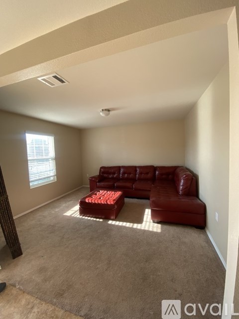 A living room with a red couch and a carpet.