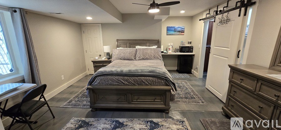 A bedroom with a large bed and a ceiling fan.
