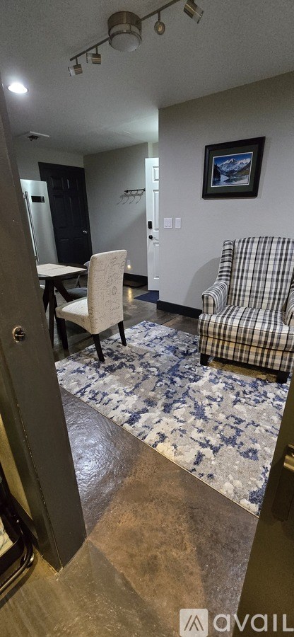 A living room with a couch, chair, and a rug.