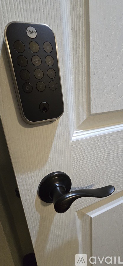 A Yale lock is mounted on a white door.