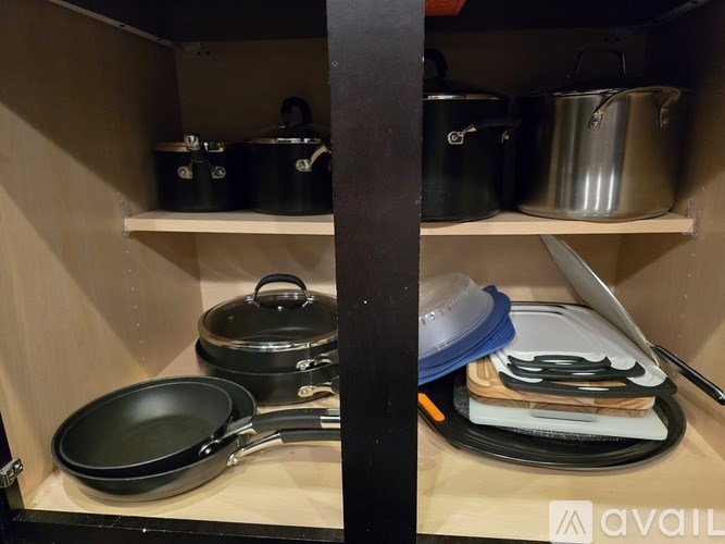 A kitchen drawer with pots, pans, and utensils.