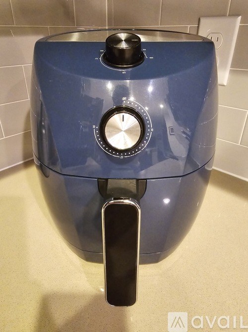 A blue electric pressure cooker on a beige countertop.