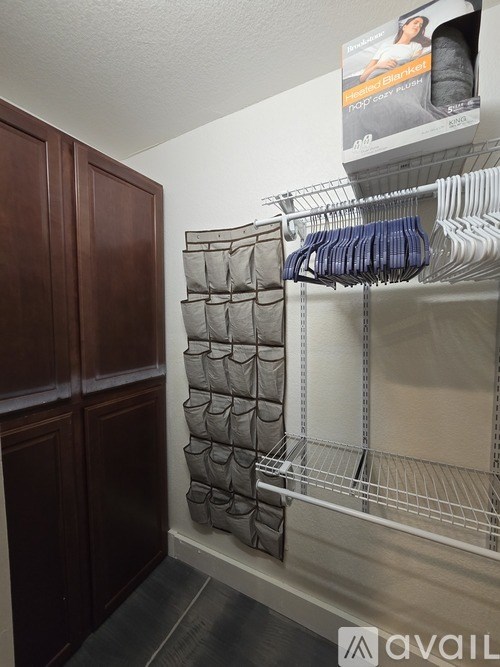 A laundry room with a rack of clothes and a cabinet.