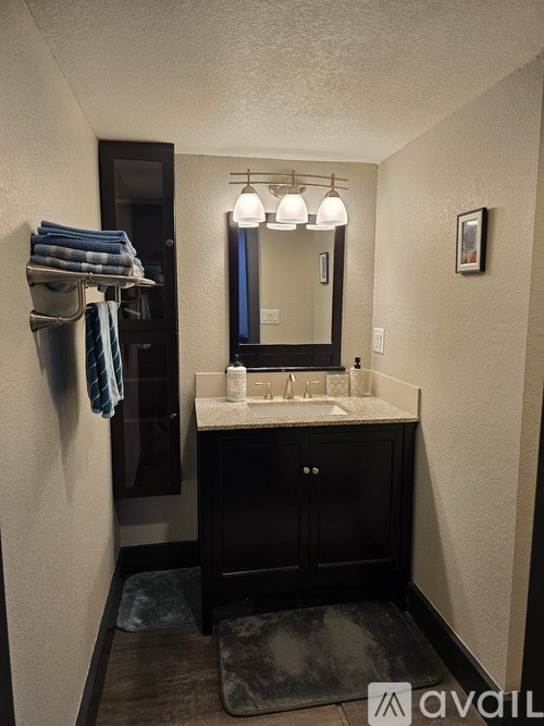 A bathroom with a sink, mirror, and towel rack.