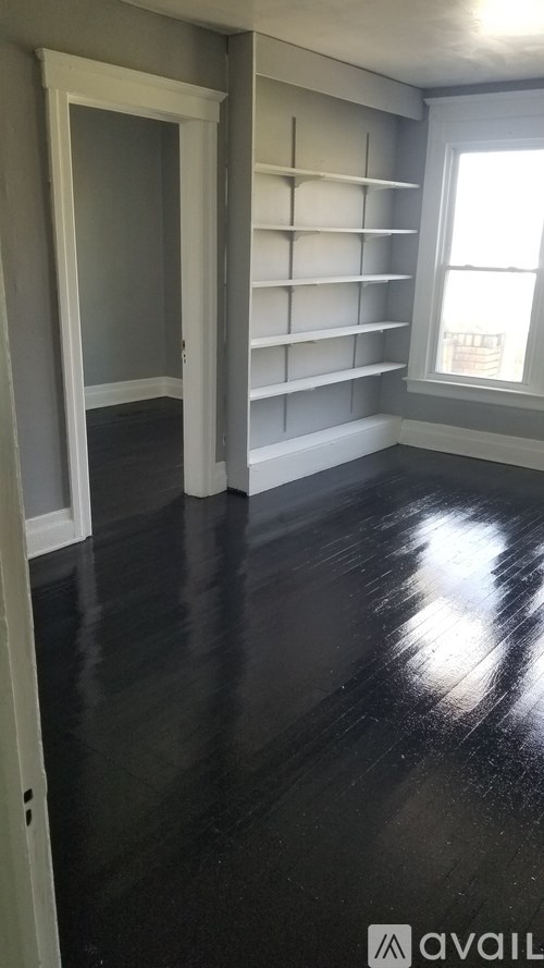 A room with a window and shelves on the wall.