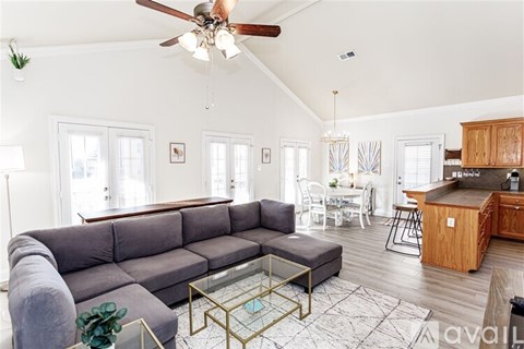 A living room with a grey couch and a glass coffee table.