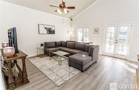 A living room with a grey sofa, a coffee table, and a ceiling fan.
