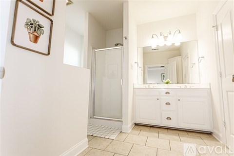 A bathroom with a white cabinet and a mirror above it.