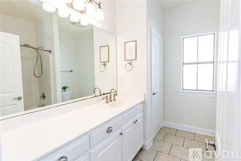 A bathroom with a white vanity and a window.