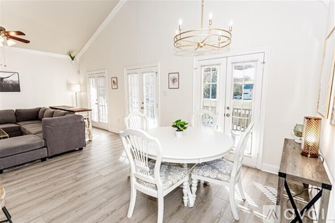 A dining room with a white table and chairs.