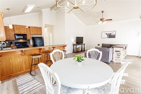 A kitchen with a dining table and chairs.